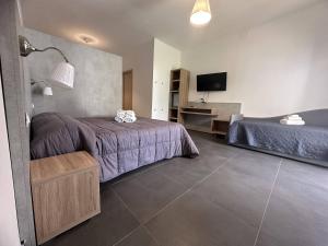 a hotel room with two beds and a television at Frontemare Hotel Village & Ristorante in Rodi Garganico