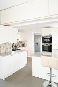 a white kitchen with white cabinets and appliances at Valesmoor Farm in New Milton