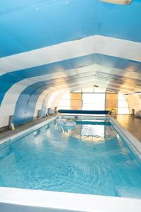 a swimming pool with blue water in a building at Valesmoor Farm in New Milton