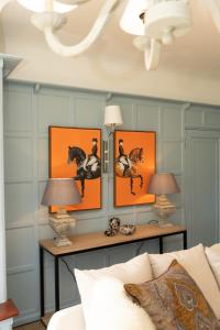 a living room with three paintings of horses on the wall at Valesmoor Farm in New Milton