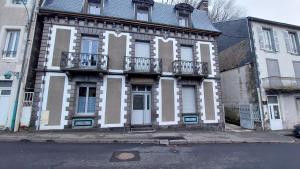 een oud gebouw met witte en bruine versieringen in een straat bij Villa de la dore in Le Mont-Dore
