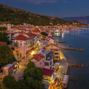 a view of a town with a harbor at night at Apartments Neptun in Baška