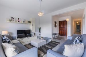 a living room with a blue couch and a tv at Stunning - SunnySide 3-Bedroom in Sliema