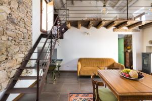 escalera de caracol en una sala de estar con mesa en Baglio Maranzano - Don Carlo, en Buseto Palizzolo