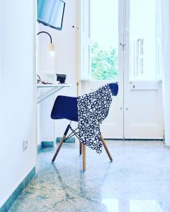una sedia blu seduta in una cucina accanto a una finestra di Dimora Casanello a Lecce