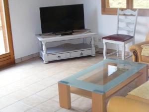 a living room with a tv and a coffee table at le chalet in Saint-Nabord