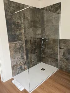 y baño con ducha y puerta de cristal. en G83Home-Appartamento moderno in zona Fiera en Vicenza