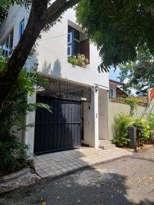 a white house with a black garage door at Colombo 07 Charming Home Stays in Colombo
