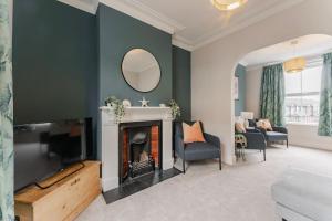 a living room with a fireplace and a mirror at Family & pet Friendly, Stylish & Spacious Beach House in Gorleston-on-Sea