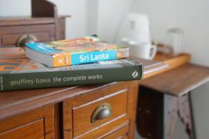 two books sitting on top of a wooden desk at Colombo 07 Charming Home Stays in Colombo