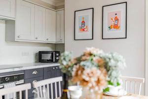 a kitchen with a table with a vase of flowers at Family & pet Friendly, Stylish & Spacious Beach House in Gorleston-on-Sea