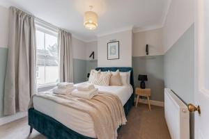 a bedroom with a large bed with towels on it at Family & pet Friendly, Stylish & Spacious Beach House in Gorleston-on-Sea