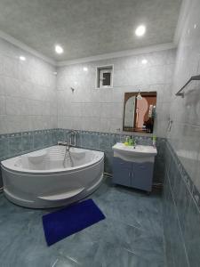 een badkamer met een groot bad en een wastafel bij Green Garden in Idzjevan