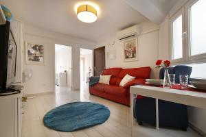 a living room with a red couch and a blue rug at Apartment Capuchinos in Málaga