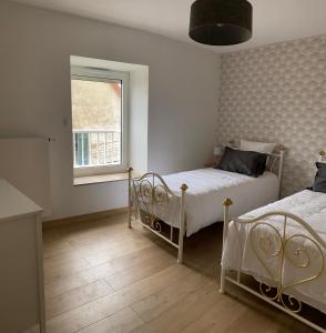 een slaapkamer met 2 bedden en een raam bij Gîte en plein cœur des vignobles in Paris-lʼHôpital