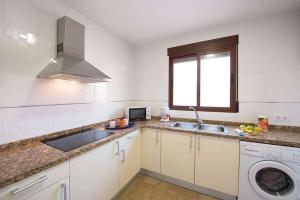 a kitchen with a sink and a washing machine at Villa Ambar - PlusHolidays in Calpe