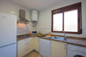 a kitchen with white cabinets and a sink and a window at Villa Ambar - PlusHolidays in Calpe