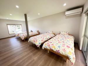 a room with three beds and a mirror at ゆふの音 in Yufu