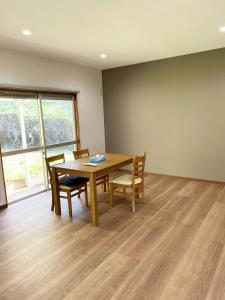 a dining room with a wooden table and chairs at ゆふの音 in Yufuin