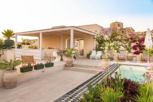 a house with a patio with plants and a pool at Aurispa in Noto
