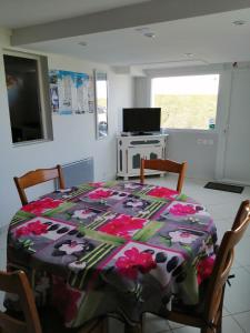 a dining room with a table with a blanket on it at gîte vacances in Moncontour