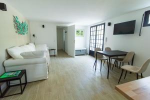 a living room with a couch and a table at Pyla sur mer proche plages appartement avec piscine in Pyla-sur-Mer