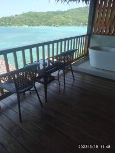 balkon z 2 krzesłami i stołem oraz ocean w obiekcie Koh Tao Relax Freedom Beach Resort w Ko Tao