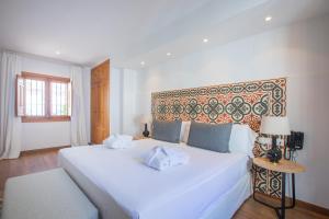 a bedroom with a large white bed with a headboard at Soho Boutique Atalia in Córdoba