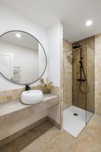La salle de bains est pourvue d'un lavabo et d'un miroir. dans l'établissement MAYA Appartements & Suites, à Cosne Cours sur Loire