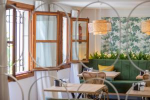コルドバにあるSoho Boutique Ataliaのテーブルと緑のソファのあるレストラン