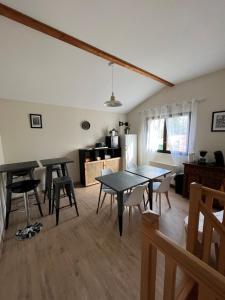 een woonkamer met 2 tafels en een keuken bij Le chat perché in Saint-Julien-en-Born