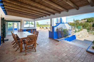 a dining room with a table and chairs on a patio at Shantivillas Malhão in Azinhal