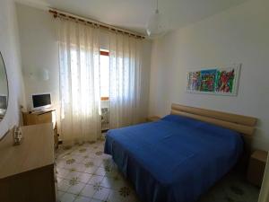 バーリにあるCasa Vacanze MaMareのベッドルーム(青いベッド1台、窓付)