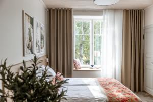 Schlafzimmer mit einem Bett und einem Fenster in der Unterkunft Old Hapsal Hotel in Haapsalu