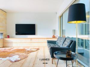 a living room with a couch and a tv at stunning luxury duplex downtown Knokke in Knokke-Heist