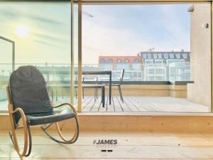 a chair sitting on top of a balcony with a table at stunning luxury duplex downtown Knokke in Knokke-Heist