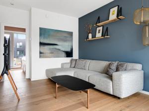 a living room with a couch and a blue wall at Sanders Pier - Fantastic 3-Bedroom Townhouse with Balcony Terrace in Copenhagen