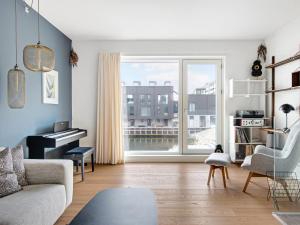 uma sala de estar com um piano e um sofá em Sanders Pier - Fantastic 3-Bedroom Townhouse with Balcony Terrace em Copenhaga