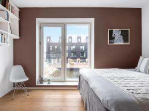 a bedroom with a bed and a large window at Sanders Pier - Fantastic 3-Bedroom Townhouse with Balcony Terrace in Copenhagen