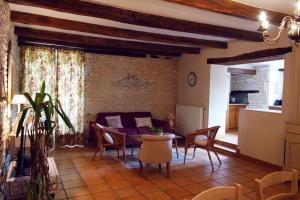 ein Wohnzimmer mit einer Couch und einem Tisch und Stühlen in der Unterkunft Le domaine de Villiers : maisons de campagne in Villiers