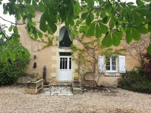 ein Haus mit einer weißen Tür und einem Fenster in der Unterkunft Le domaine de Villiers : maisons de campagne in Villiers