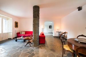 a living room with a red couch and a table at Etna Retreat in Castiglione di Sicilia