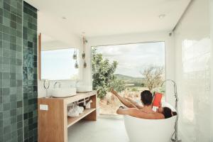 a man in a bath tub in a bathroom with a window at Cas Cabo Nou Agroturismo Adults Only in Sant Llorenç des Cardassar