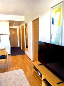 sala de estar con TV de pantalla plana grande en Premium Chalet 4212 Green en Heinola