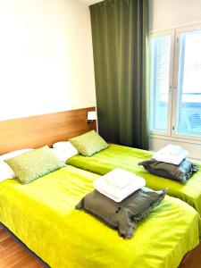 two beds in a room with yellow sheets at Premium Chalet 4212 Green in Heinola