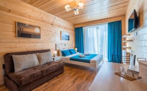 um quarto com uma cama e um sofá num quarto em New Gudauri Ski4Life em Gudauri