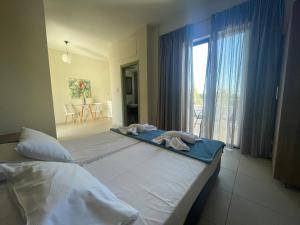a bedroom with two beds and a large window at Oleander in Platanes