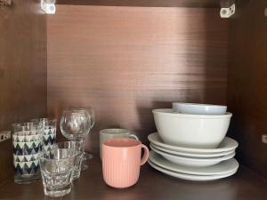 a shelf with plates and glasses on a table at Oleander in Platanes