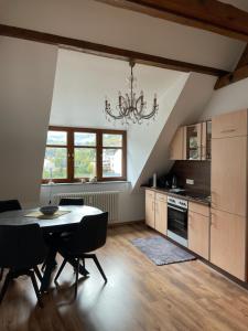 a kitchen with a dining room table and a chandelier at FEWO Königsberg Weingut C A Haussmann in Traben-Trarbach