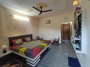 um quarto com uma cama com um edredão colorido em Four Season Homestay Bhowali Bhimtal em Bhowāli
